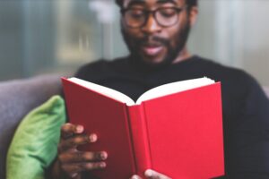 young black man reading red book