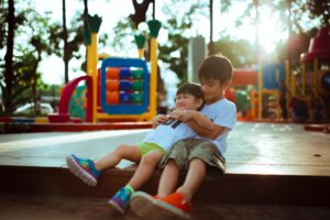 two little boys hugging at a playground park