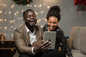 Two people looking at a tablet device and smiling