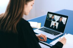young woman having an online meeting with three people