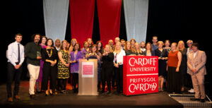 A large group of people on stage after winning at the Cardiff University excellence awards