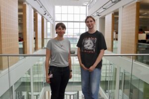 Photo of Dr Joanna Martin (Left) and Ellie (left) on the bright open balcony of the Hadyn Ellis Building